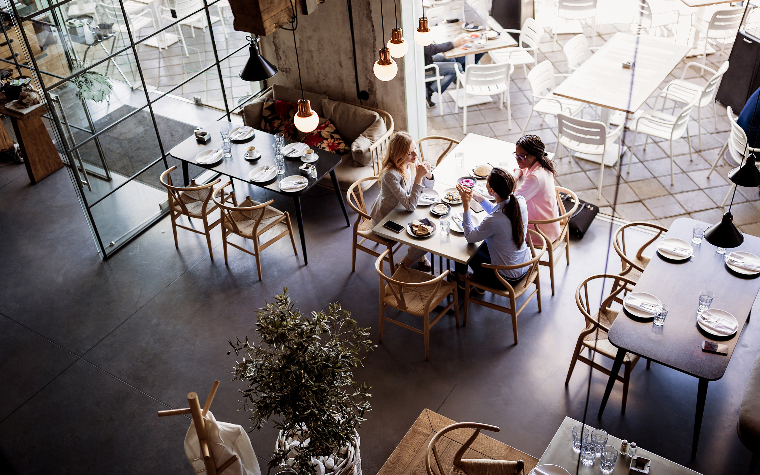 Three friends talking while sitting around a table at a coffee shop