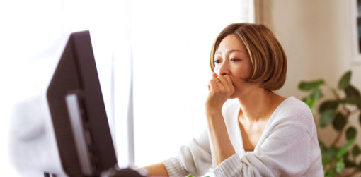 a woman is seated at her computer