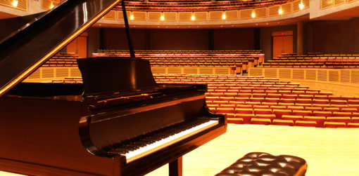 a baby grand piano on a concert hall stage