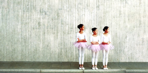 Three young ballerinas in a line.