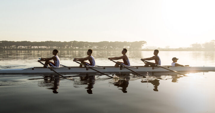 Four-person rowing team races across the water