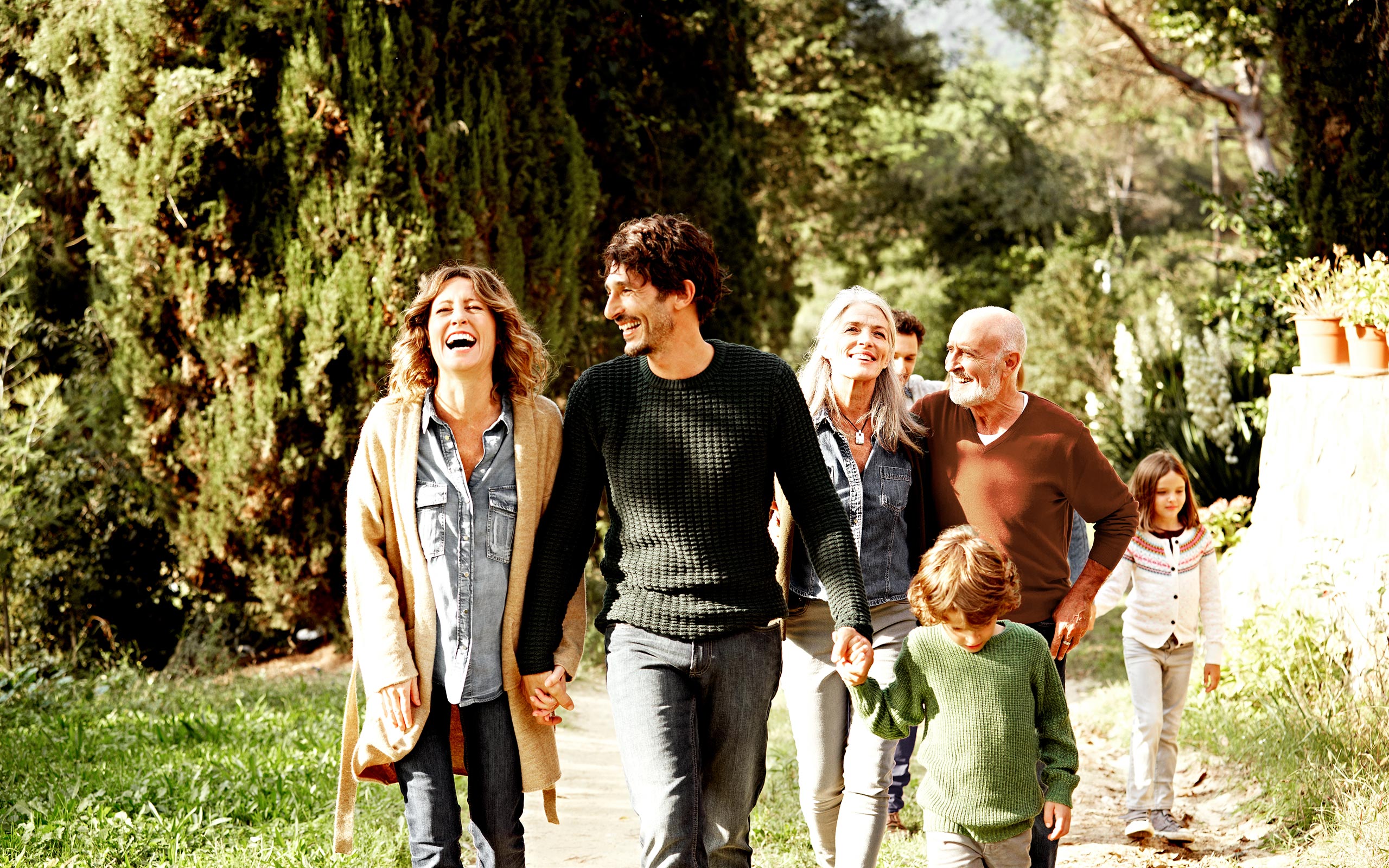 A multigeneration family walking down a path