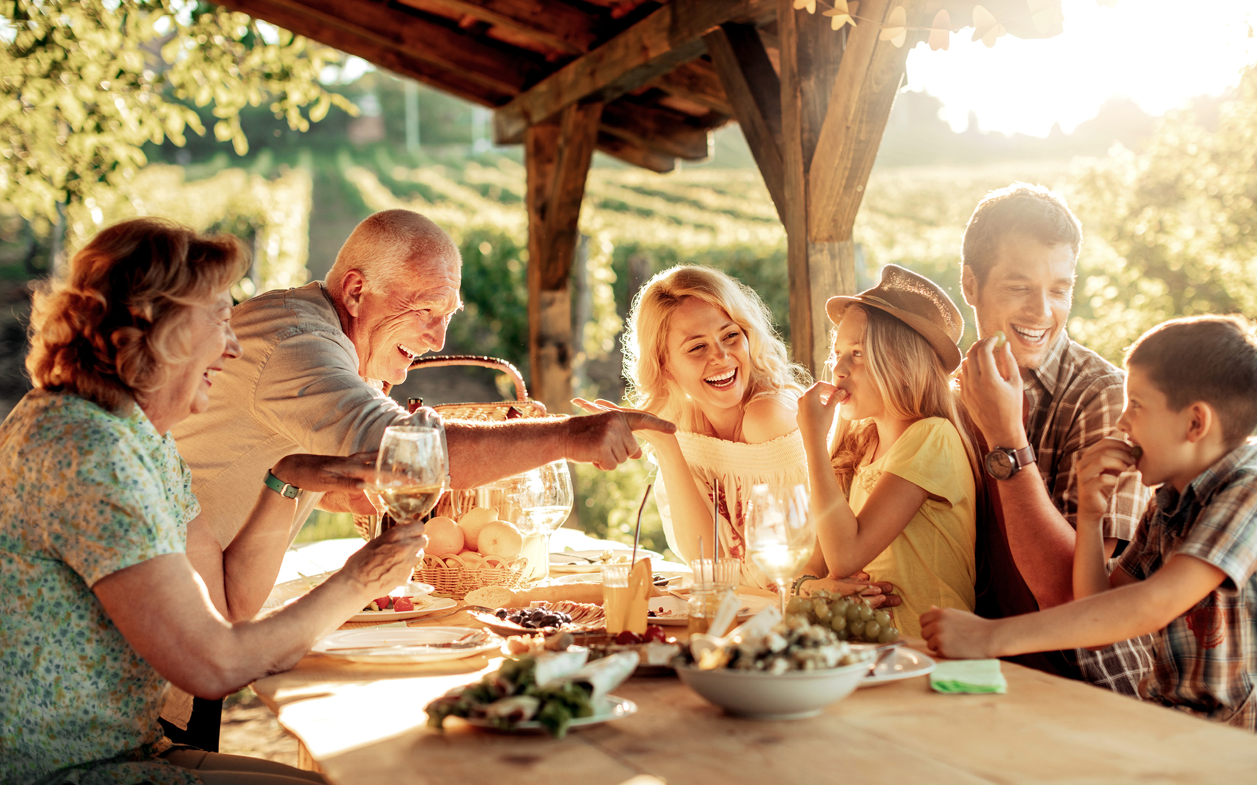 Multigenerational family seated at a table under a gazebo