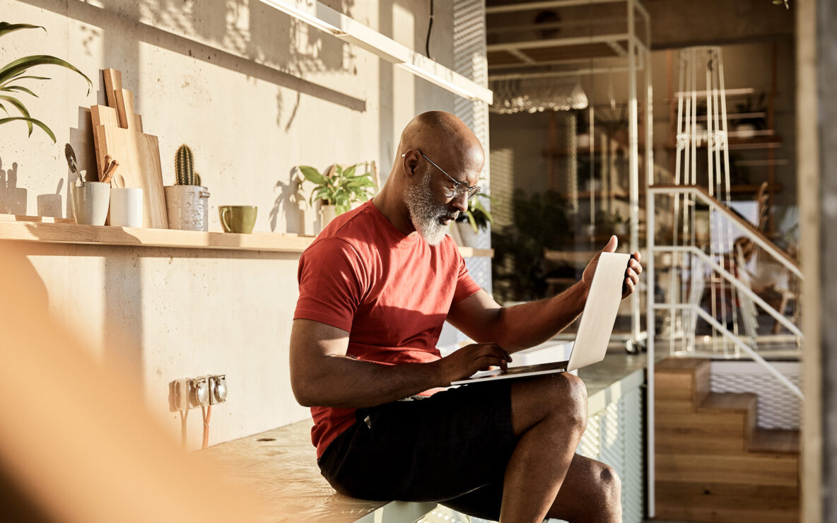 Man seated with laptop inside a home
