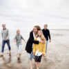A multigenerational family walking on the beach.