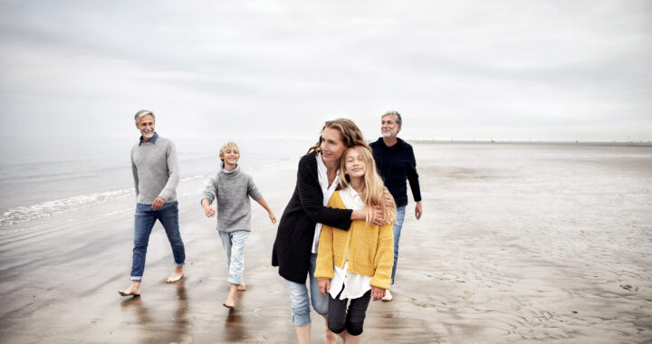 A multigenerational family walking on the beach.