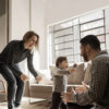 A young boy with a disability walking toward his father in the living room