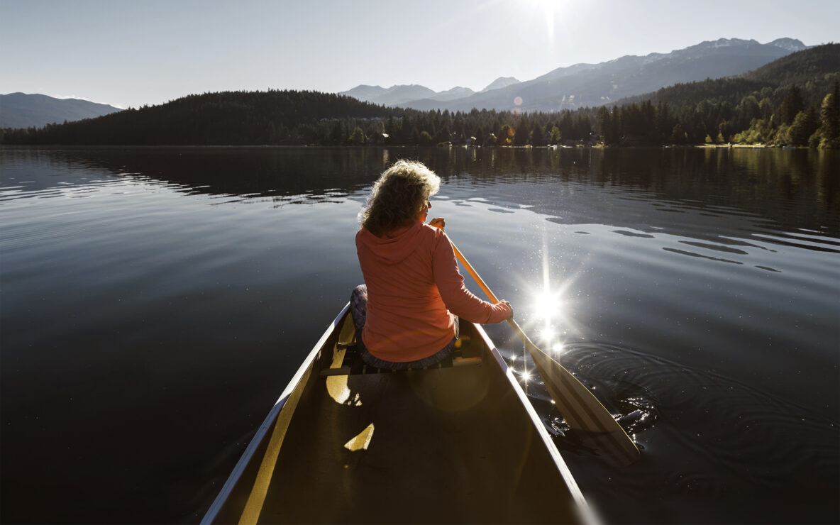 Senior aged woman canoeing in the lake.