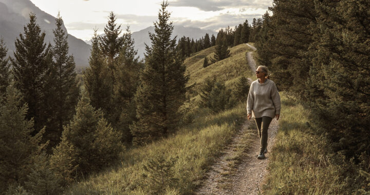 Woman walks down trail in the morning.