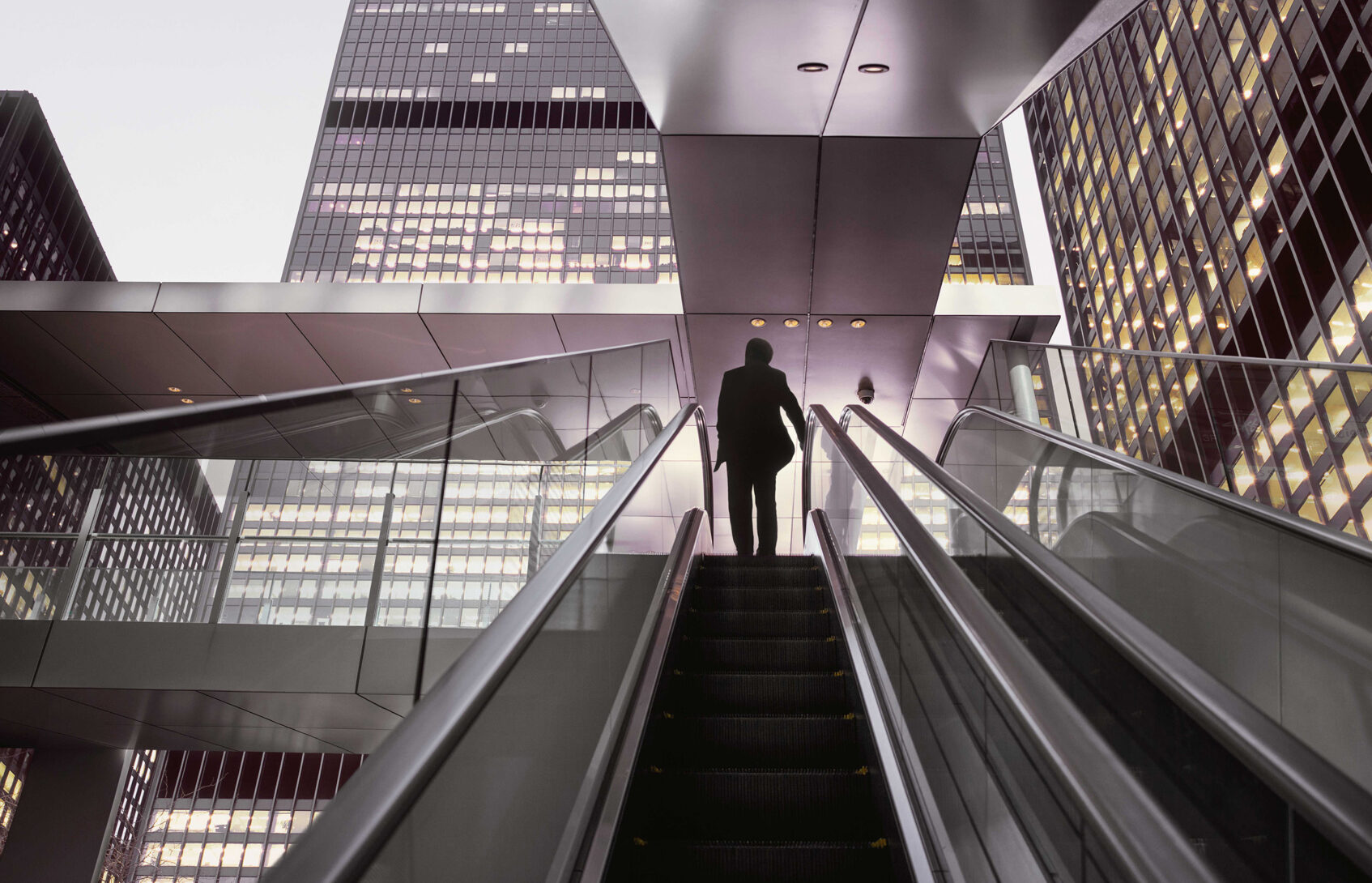 Businessman on top of moving escalator