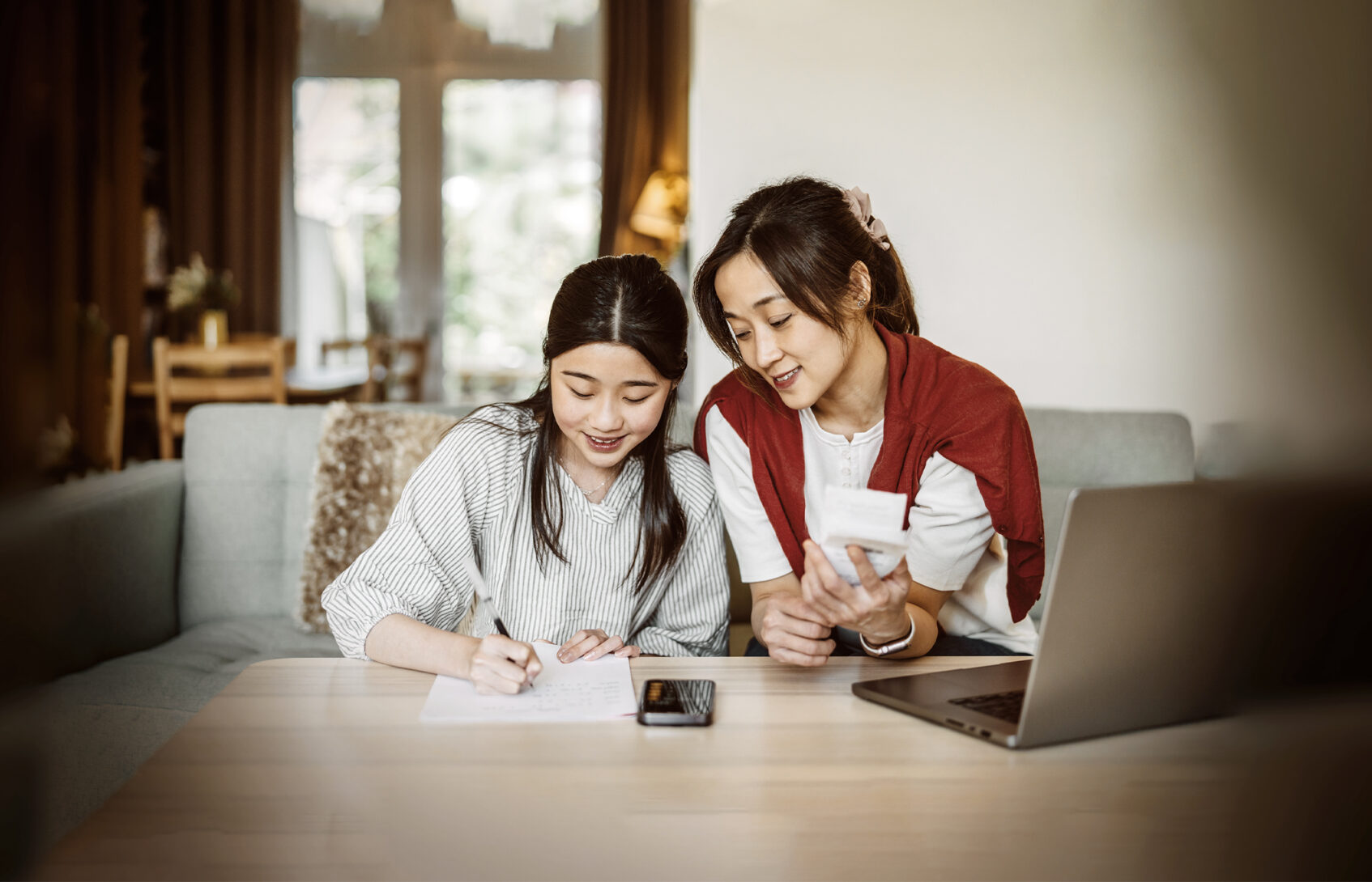 A mother shows her daughter how to manage finances