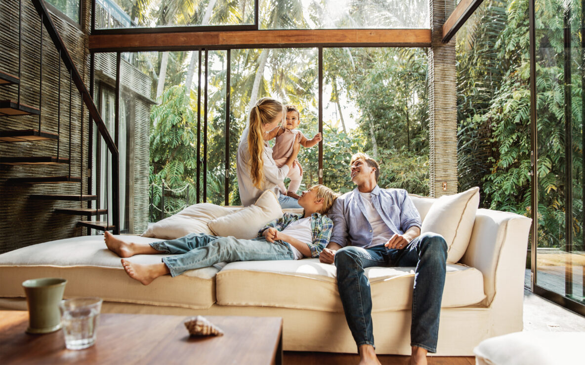 A young family seated on the sofa in the living room.