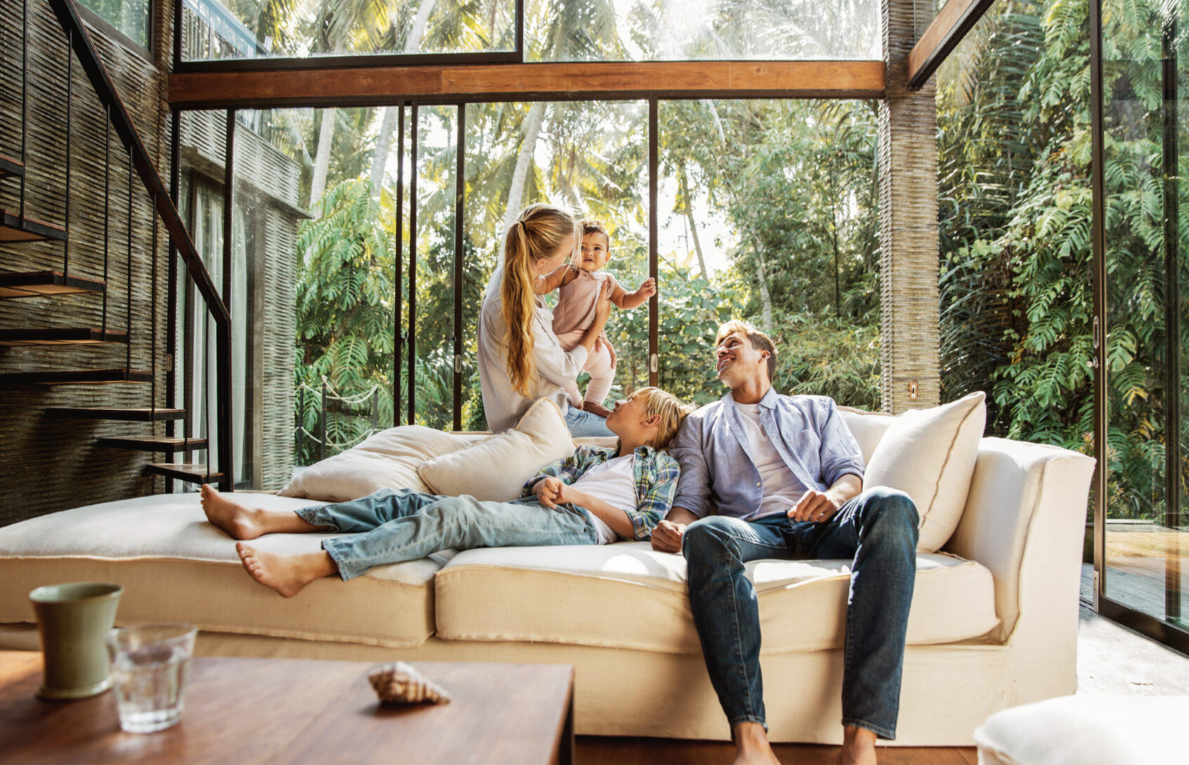 A young family seated on the sofa in the living room.