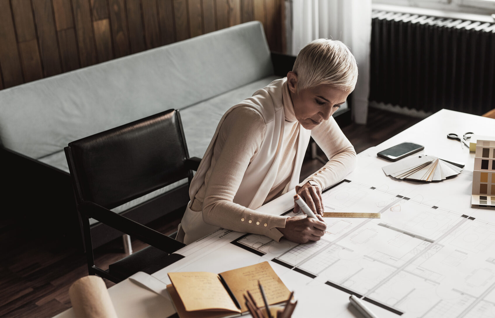 Businesswoman drawing plans in home studio.