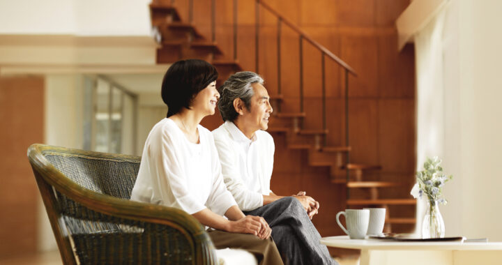Senior couple seated in living room.